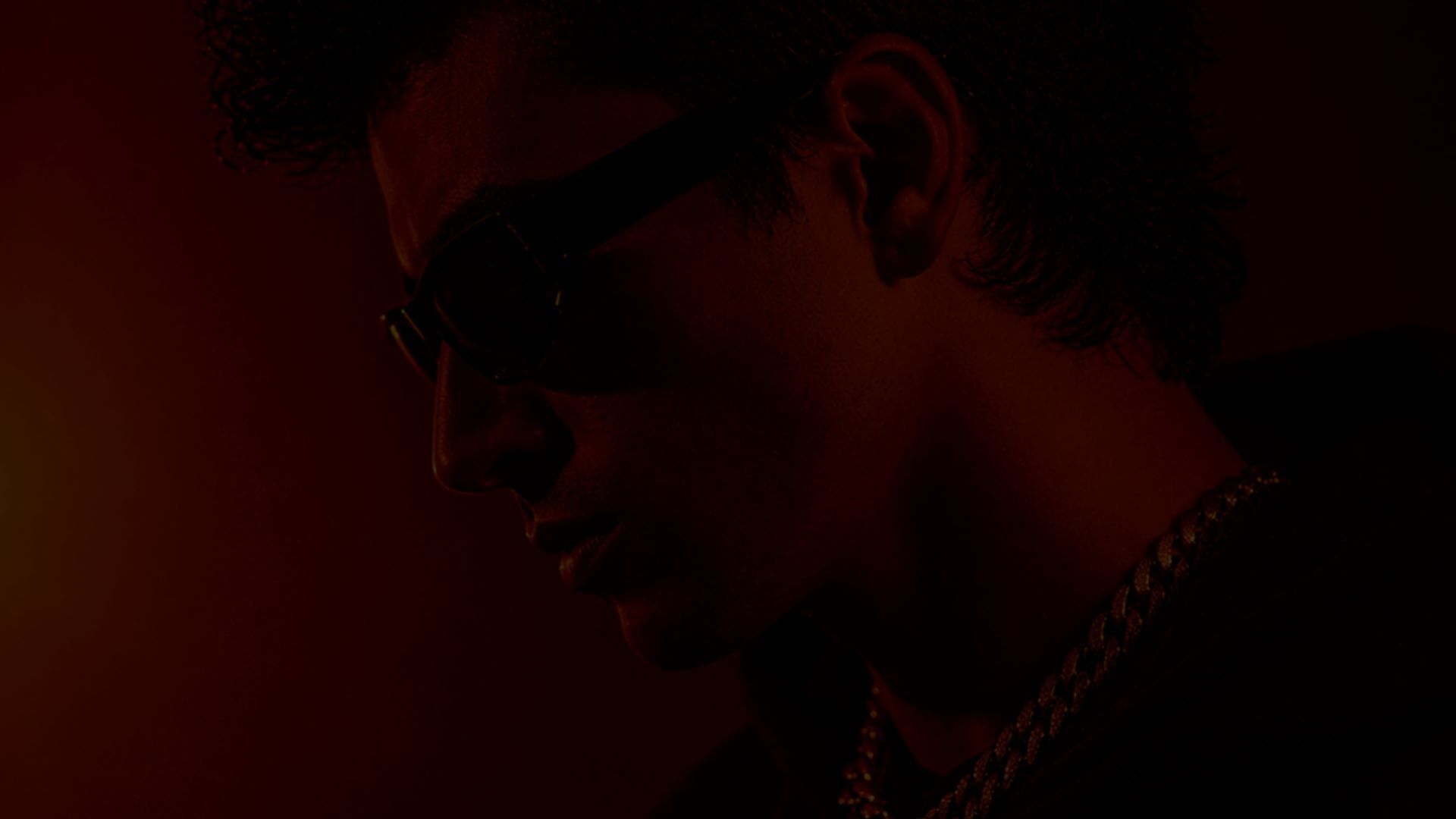 Portrait of Nick Tribe seated against a studio backdrop